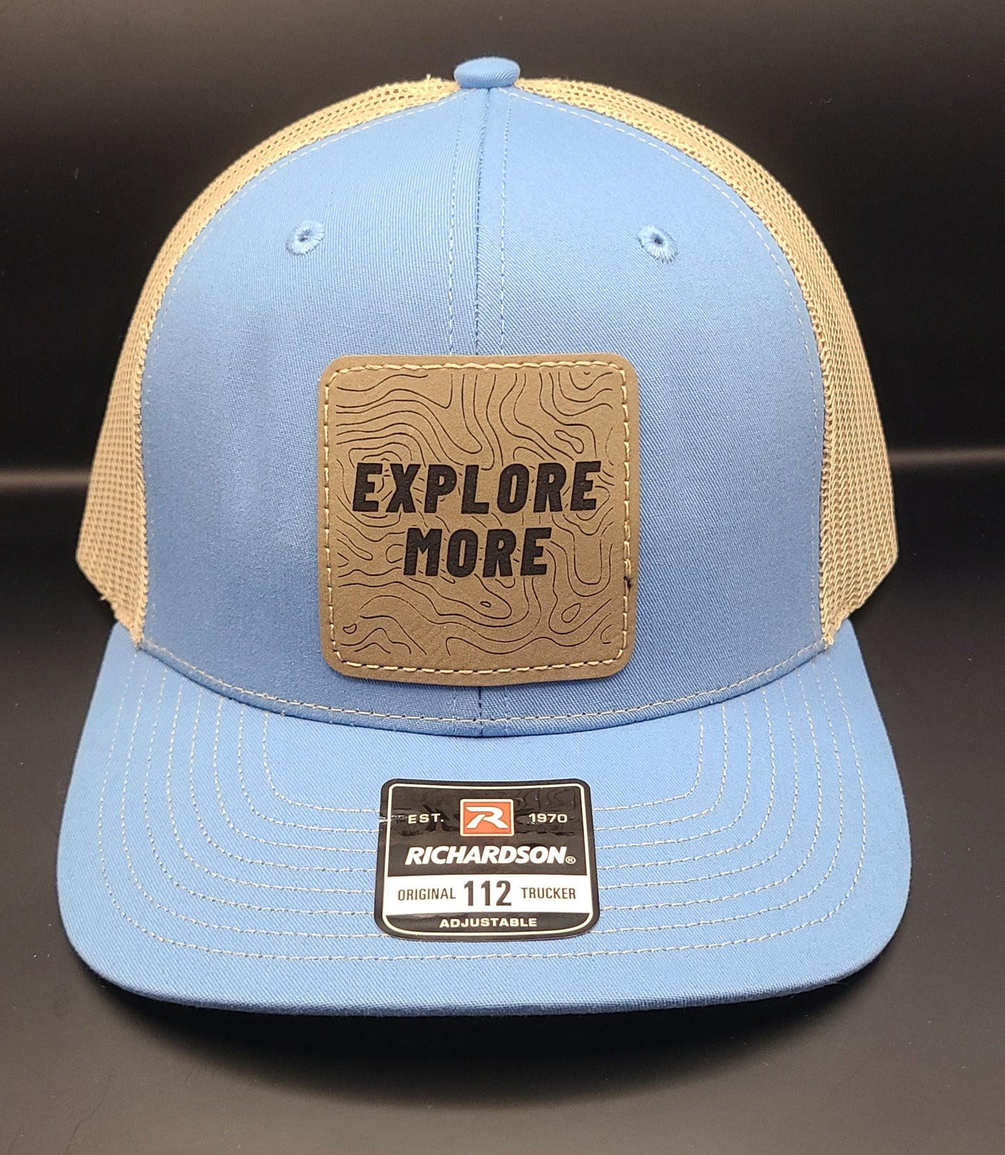 TRUCKER HAT WITH SQUARE PATCH THAT SAYS "EXPLORE MORE" (COLUMBIA BLUE/KHAKI)